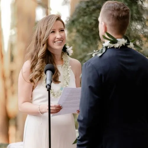 A woman reading her vows to a man at her wedding